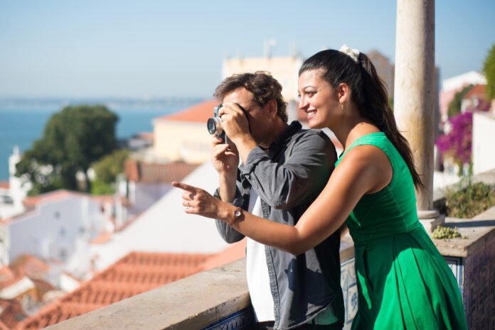 Portrait of loving couple taking photos of summer sea and city