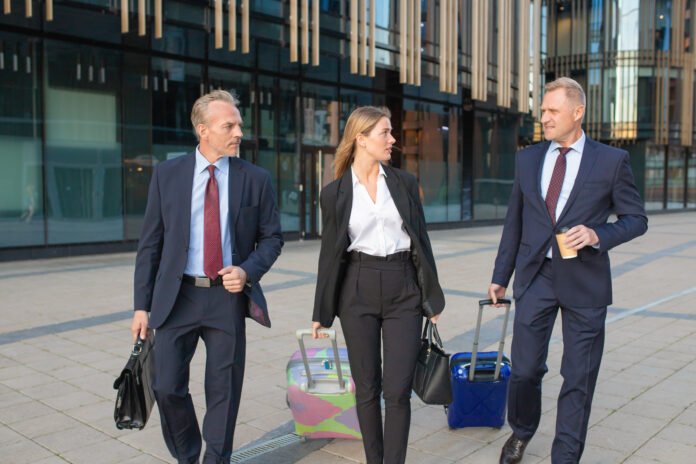 Confident businesspeople travelling with luggage
